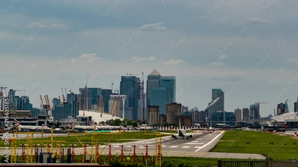 8k Timelapse view of the City airport in London with airplanes landing and taking off, office buildings in the background 8k Timelapse view of the City airport in London with airplanes landing and taking off, office buildings in the background