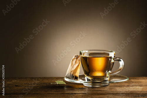 glass cup of tea with tea bag on wooden table