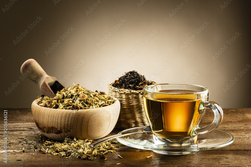 glass cup of tea with different herbal tea on wooden table glass cup of tea with different herbal tea on wooden table