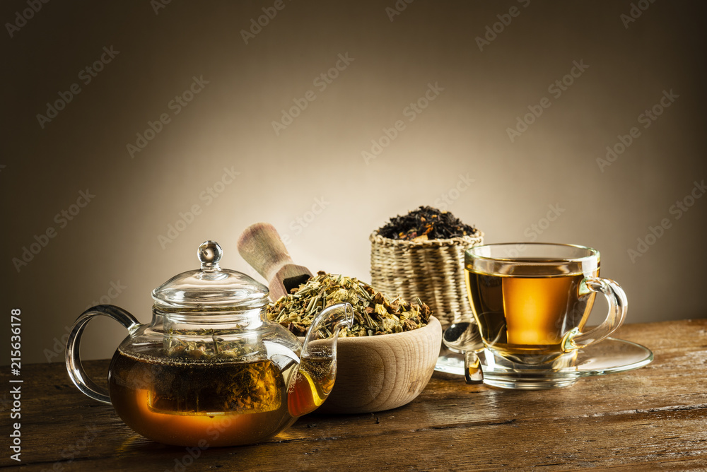glass teapot with cup and herbal tea on wooden table glass teapot with cup and herbal tea on wooden table