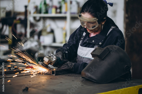 Canvastavla Strong and worthy woman doing hard job in car and motorcycle repair shop