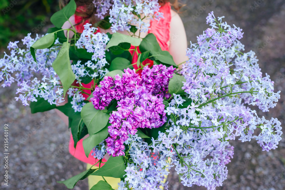 girl child holding a bouquet of lilac. girl child holding a bouquet of lilac.