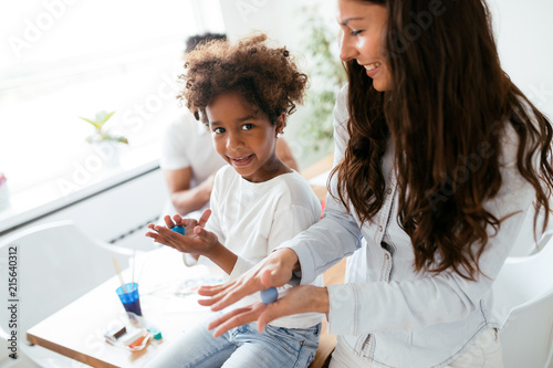 Young pretty woman and kid playing with colorful clay