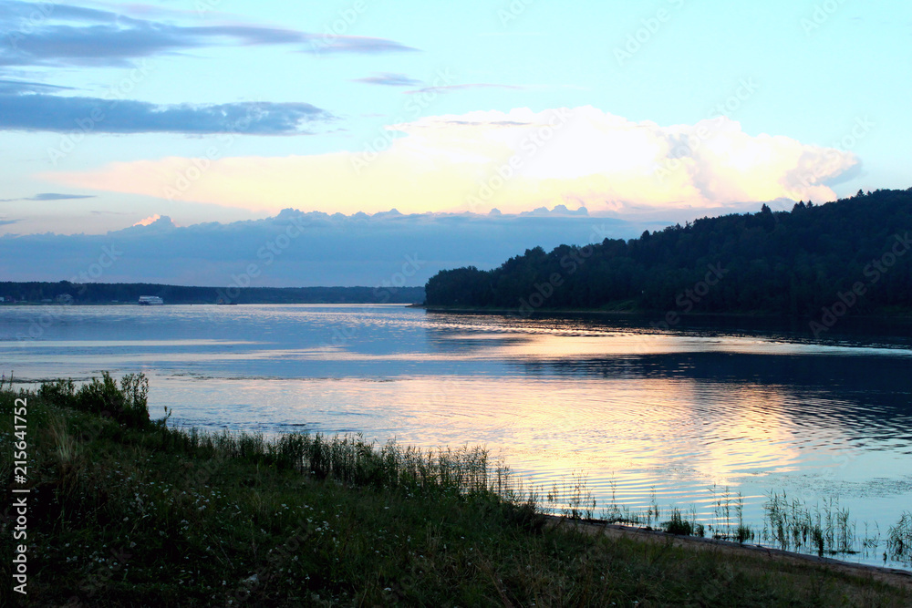 Volga river and forest on blue sky background. Sunset. Horizontal view.