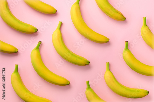 Colorful fruit pattern. Bananas over pink background. Top view. Pop art design, creative summer concept. Minimal flat lay style.