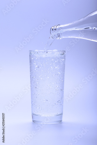 Full glass of refreshing mineral water poured from a bottle