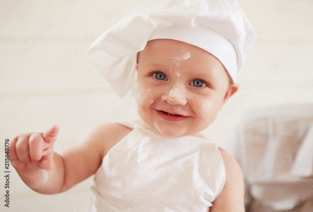 The small boy sits on the table in kitchen The small boy sits on the table in kitchen