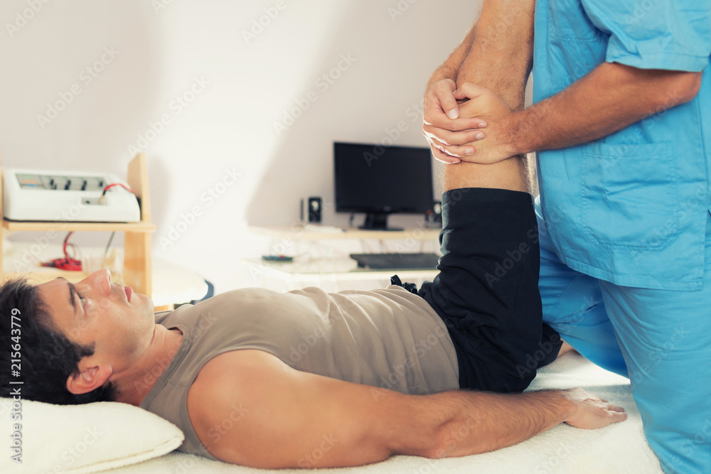 Obraz premium Physiotherapist Working With Patient Leg