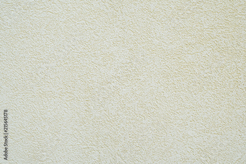 background wall with off-white or pale yellow roughcast plaster texture