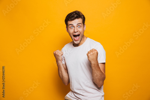 Portrait of an astonished young man celebrating success photo