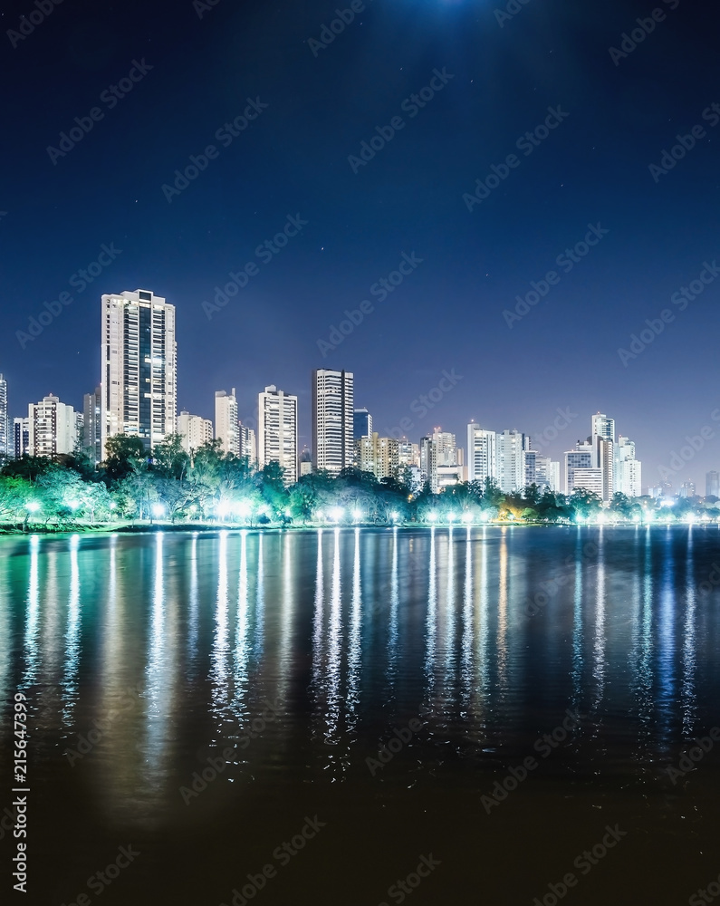 Obraz premium Pionowe zdjęcie Lago Igapo, Londrina - Parana, Brazylia. Widok na jezioro Igapo nocą i miasto, budynki w tle. Miejsce wypoczynku, turystyczne przeznaczenie miasta.