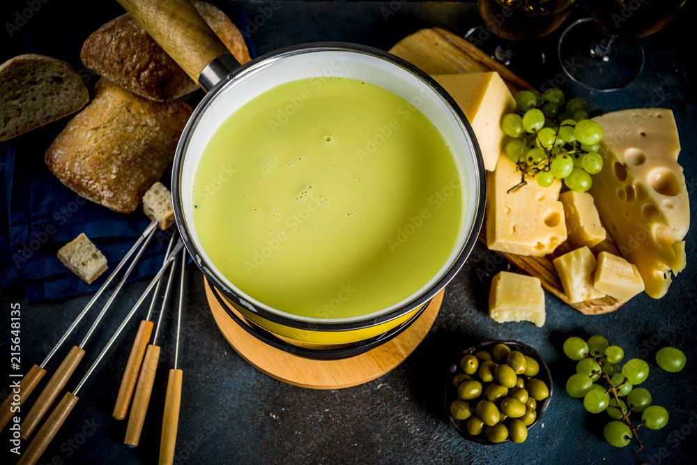 Gourmet Swiss fondue in traditional fondue pot, with forks, various