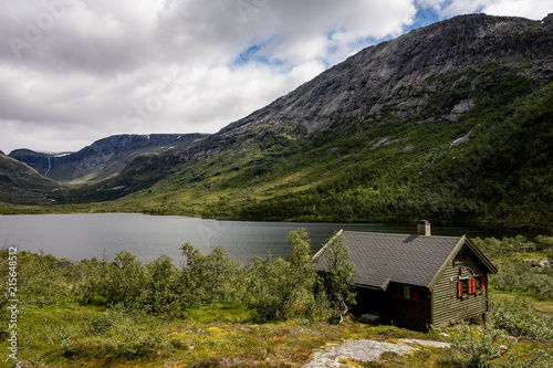 Small green cottage and Grytingsvatnet lake near Kinsarvik town in Norway