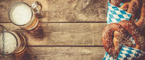 Oktoberfest concept - pretzels and beer on rustic wood background photo