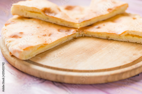Sliced pie with cheese on a wooden background. Khachapuri.