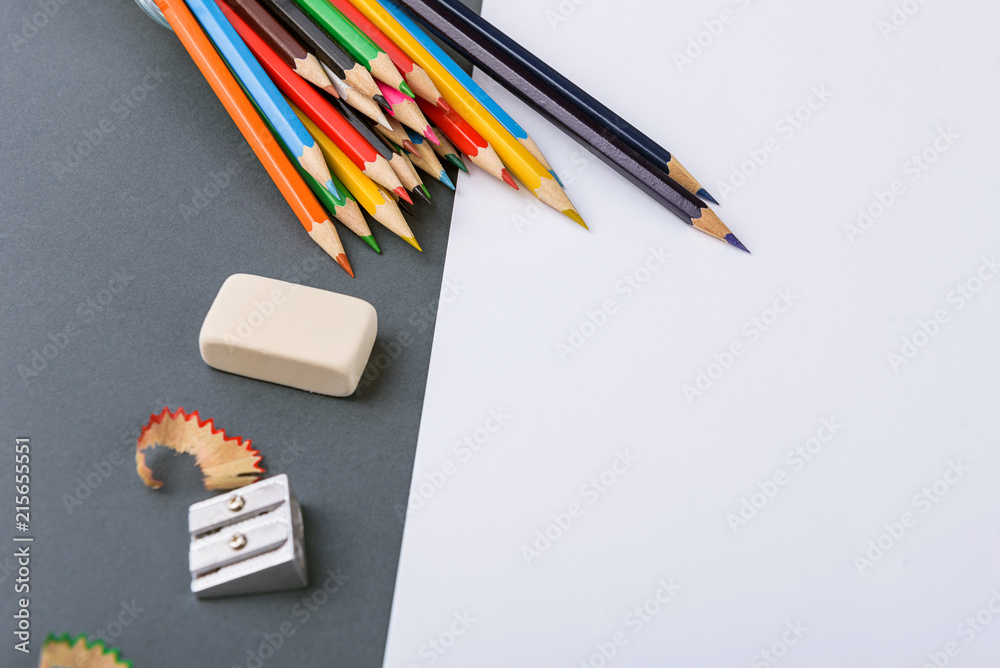 Fototapeta premium Color pencils on a gray background with a white sheet ready for drawing