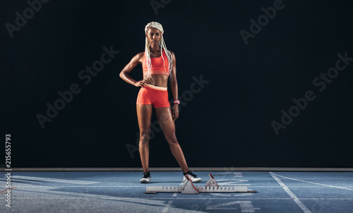 Woman sprinter standing on a running track