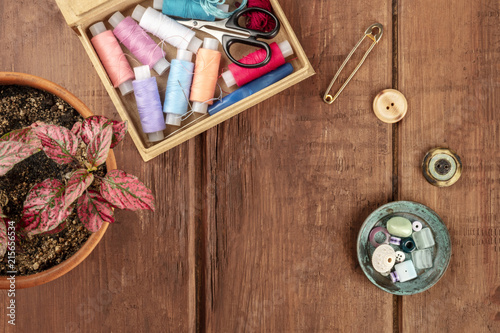 Overhead photo of sewing box with vintage pin, buttons, and copy space