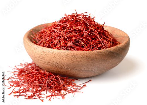 saffron thread in the wooden plate, isolated on the white background. photo