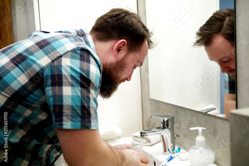 Man washing and refreshing his face.