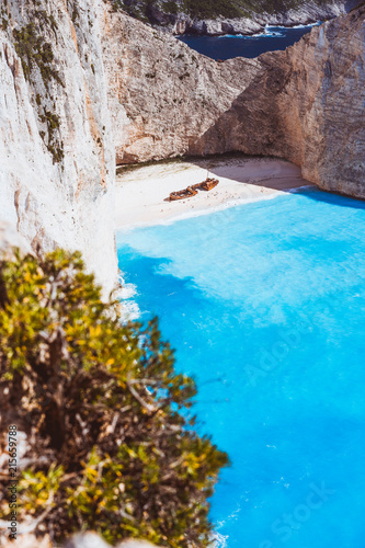 Vertical shot of shipwreck on Navagio beach with turquoise blue sea water surrounded by huge white cliffs. Famous landmark location on Zakynthos island, Greece