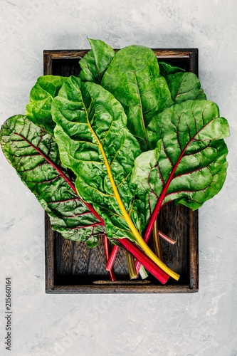 Fotografia Fresh raw swiss rainbow chard leaves on gray stone background.
