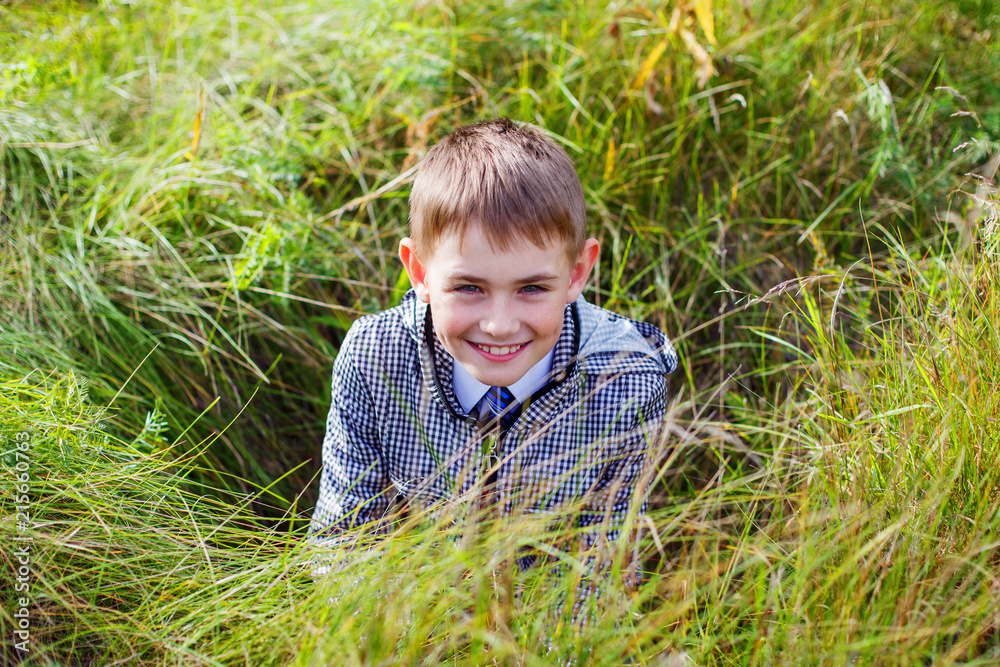 boy in black and white jacket in autumn laughing in grass boy in black and white jacket in autumn laughing in grass