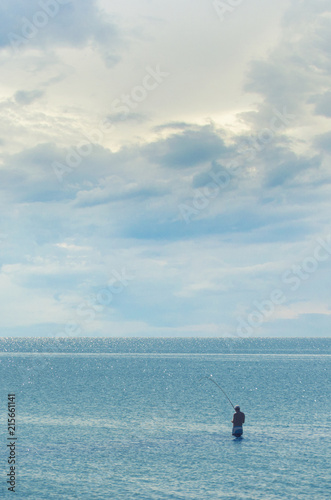 Fishing in the open sea - A man with a fishing rod catches fish in the sea