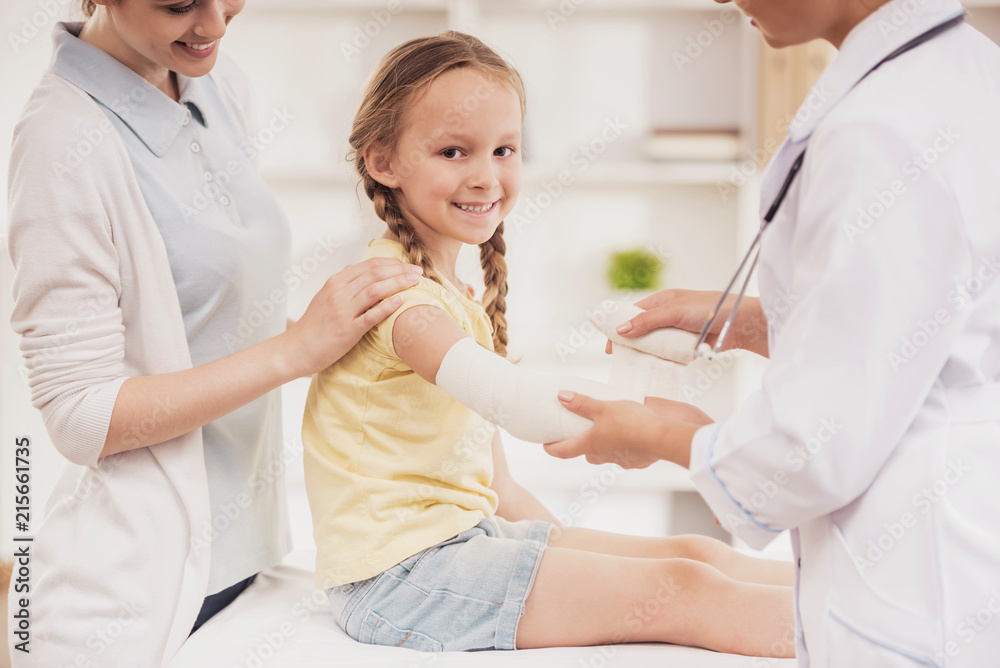 Doctor Rewinds Hand of Small Girl with Bandage. Doctor Rewinds Hand of Small Girl with Bandage.