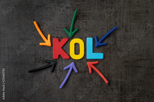 KOL abbreviation of Key Opinion Leader, influencer concept, colorful arrows pointing to the word KOL at the center of black cement wall, new social media marketing in digital world