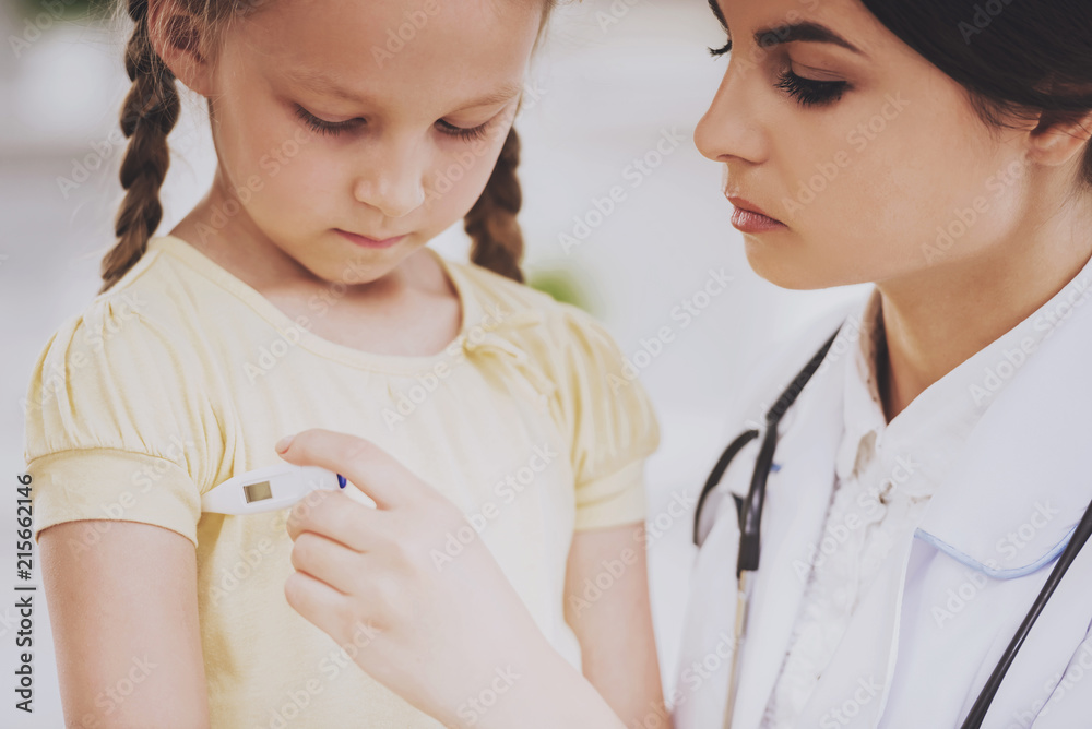 Young Female Pediatrician Measuring Temperature. Young Female Pediatrician Measuring Temperature.