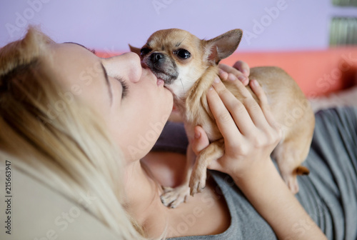 Teenage girl with her dog laying in bed photo