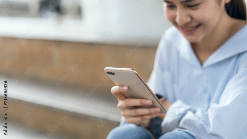 woman using smartphone on staircase in public areas, During leisure time. The concept of using the phone is essential in everyday life. woman using smartphone on staircase in public areas, During leisure time. The concept of using the phone is essential in everyday life.