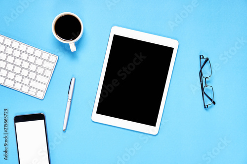 Top view, Modern workplace with tablet with smart phone placed on a pastel blue background. Copy space suitable for use in graphics.