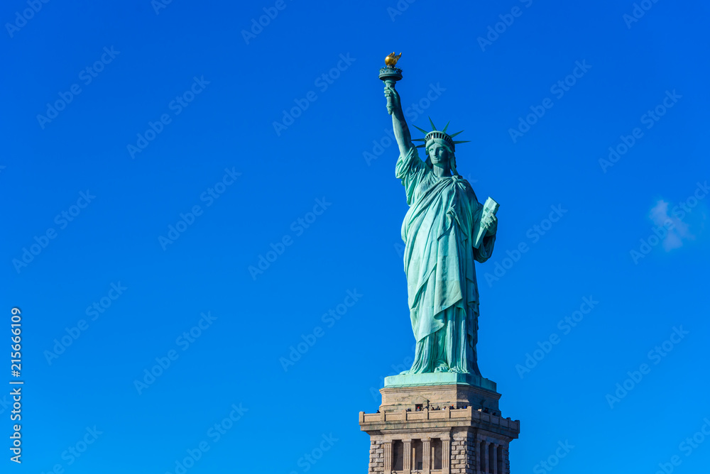Obraz premium Statua Wolności w słoneczny dzień z błękitnym niebem, Nowy Jork, USA