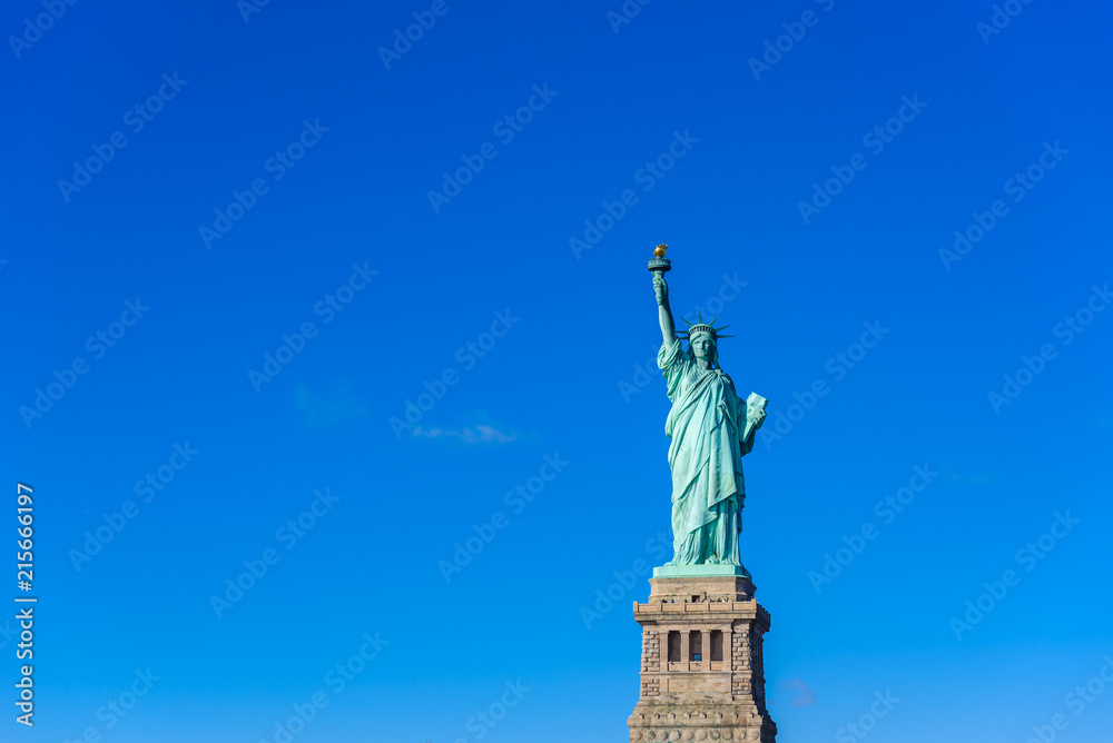 Fototapeta premium The statue of Liberty at a sunny day with blue sky, New York City, USA