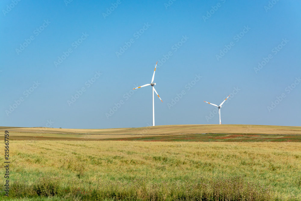 Fototapeta premium Modern wind farm with big wind turbines towers, source for renewable green energy