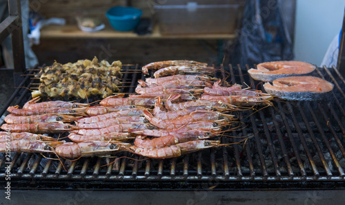 Cooking fresh king's shrimp on a grill on a foodfest. photo