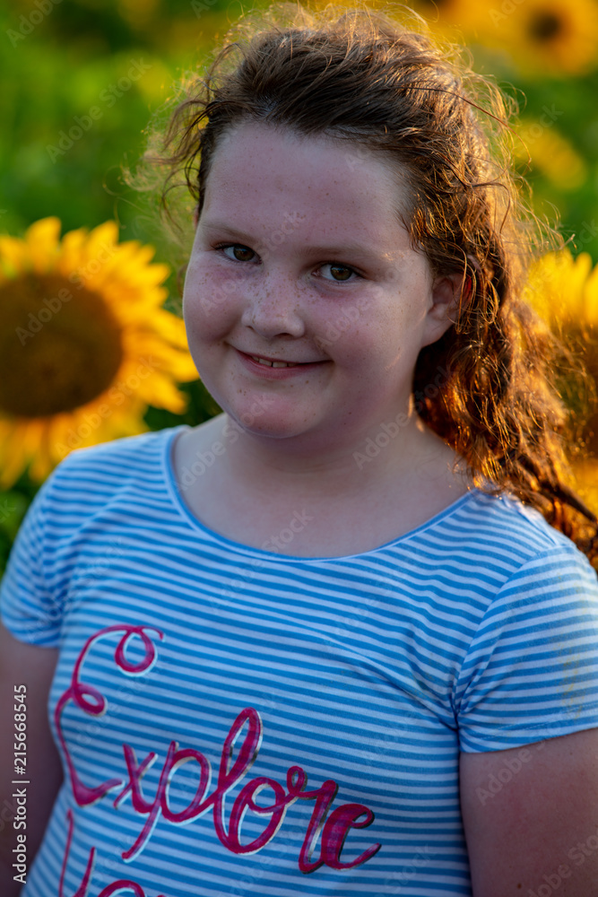 Beauty joyful young girl with sunflower enjoying nature and laughing on summer sunflower field. Sunflare, sunbeams, glow sun. Backlit. Beauty joyful young girl with sunflower enjoying nature and laughing on summer sunflower field. Sunflare, sunbeams, glow sun. Backlit.