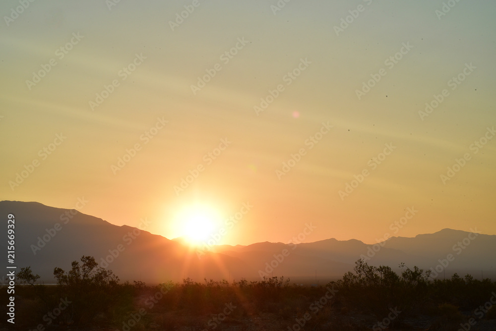 long exposure photos of the sun rising over the ridge of the Spring Mountains in the Mojave Desert town of Pahrump, Nevada, USA