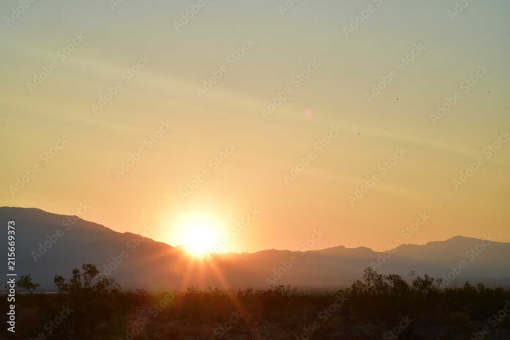 Fototapeta premium long exposure photos of the sun rising over the ridge of the Spring Mountains in the Mojave Desert town of Pahrump, Nevada, USA