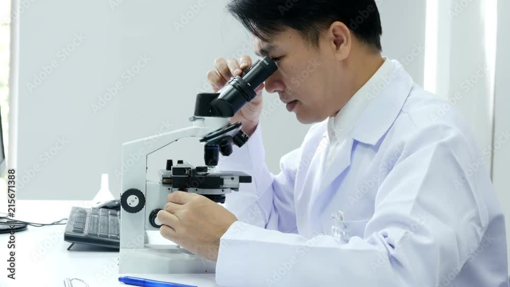 Male Scientist looking to microscope with assistance. People with medical, science, doctor, healthcare concept. 4K Resolution. Male Scientist looking to microscope with assistance. People with medical, science, doctor, healthcare concept. 4K Resolution.