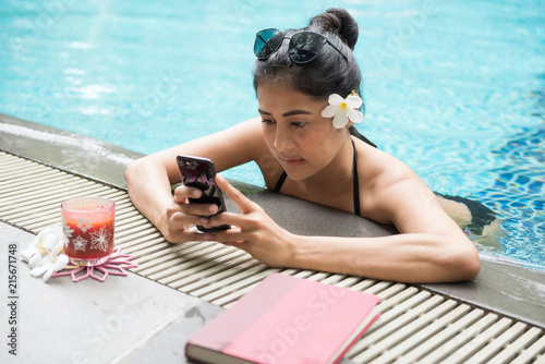 Sexy woman play smartphone at pool photo