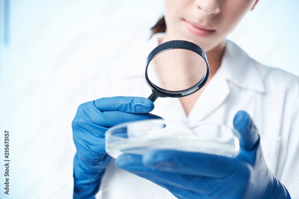 laboratory assistant with a magnifying glass Petri dish laboratory assistant with a magnifying glass Petri dish