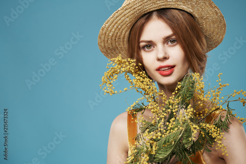 woman in a hat with flowers on a blue background