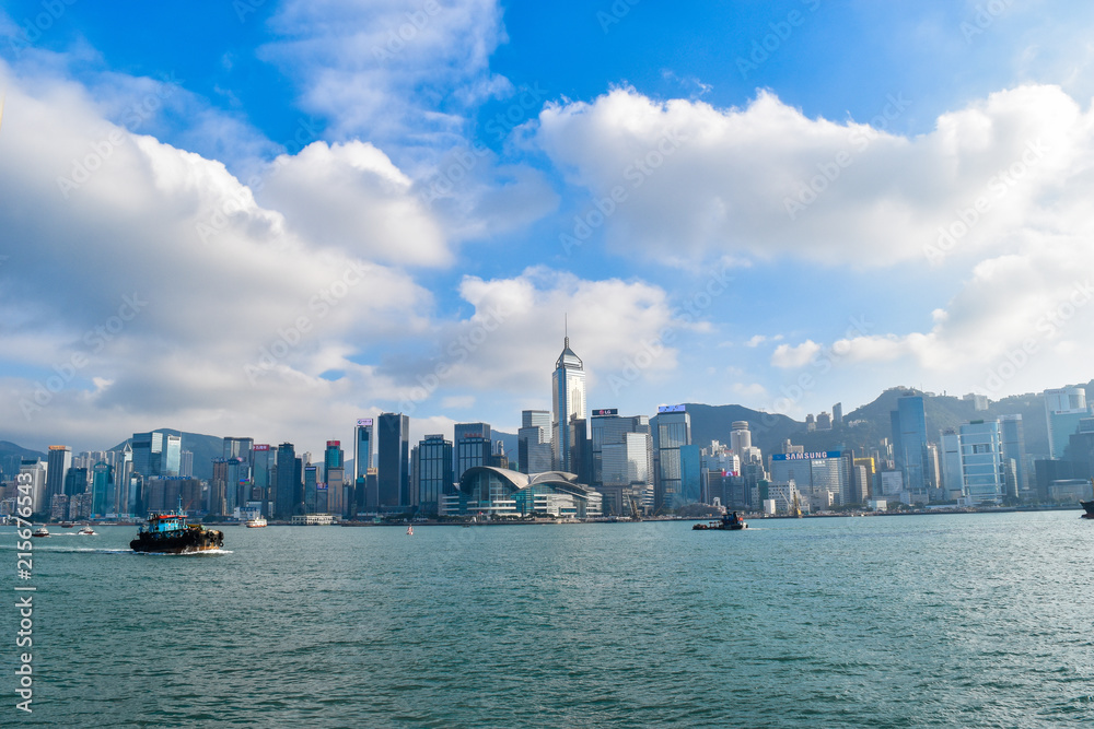 Hong Kong - November 16, 2017 : Sunshine white cloud on blue sky meteorology weather with high building iconic skyline at kowloon bay that habour hong kong by coming ferry, beautiful scenery