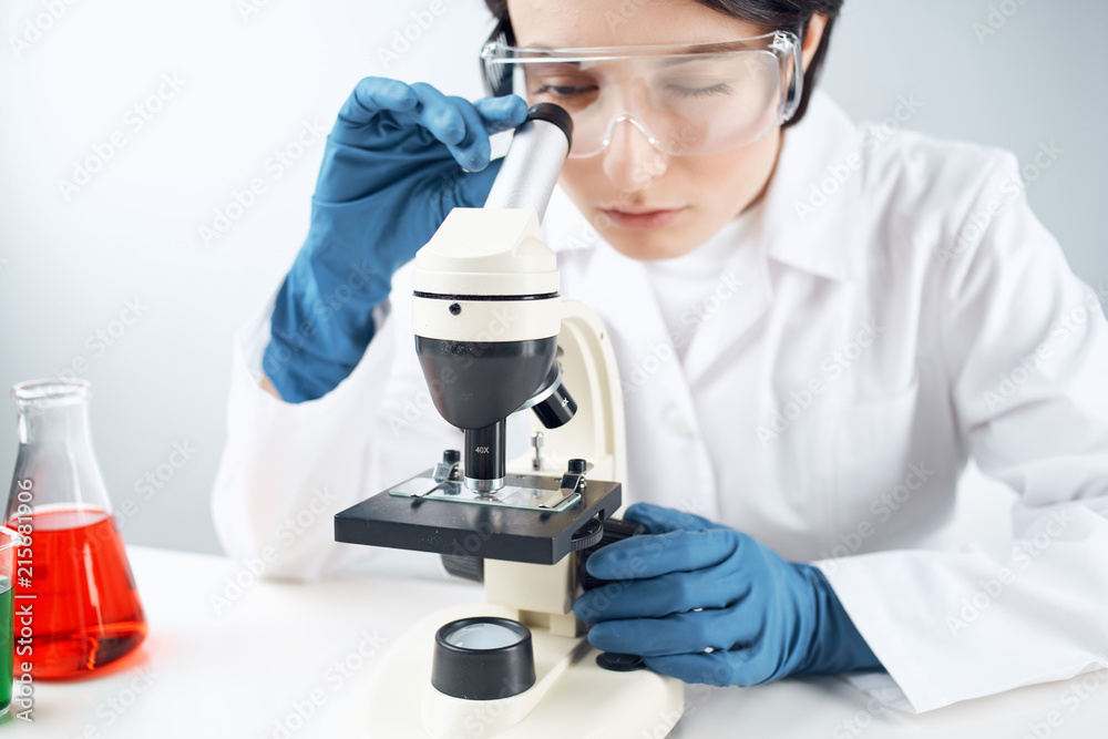 laboratory assistant in glasses with a microscope laboratory assistant in glasses with a microscope