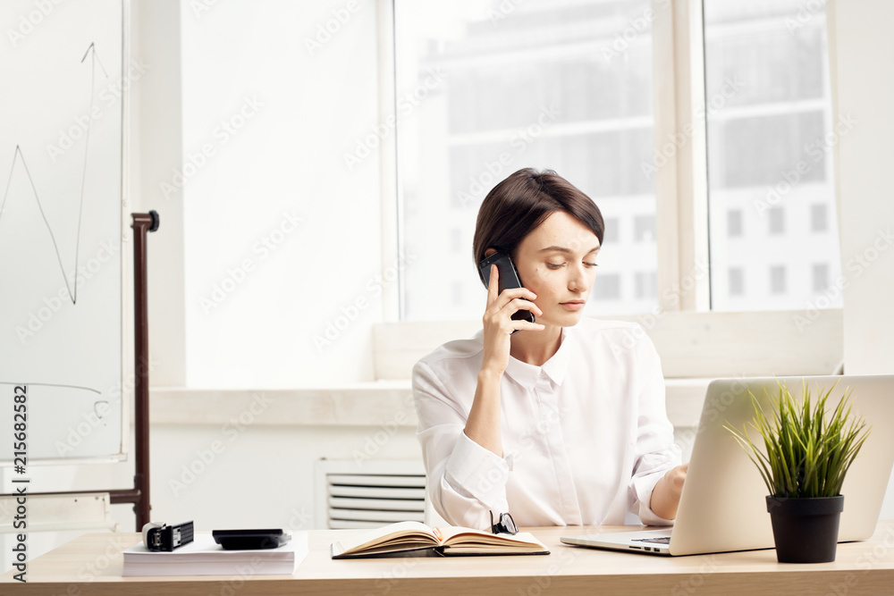 business woman in the office talking on the phone business woman in the office talking on the phone