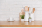 Kitchen utensils and dishware on wooden shelf. Kitchen interior background