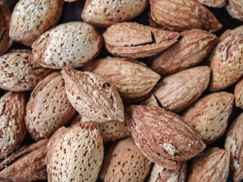 Almond nut in shell and shelled on wooden background Almond nut in shell and shelled on wooden background